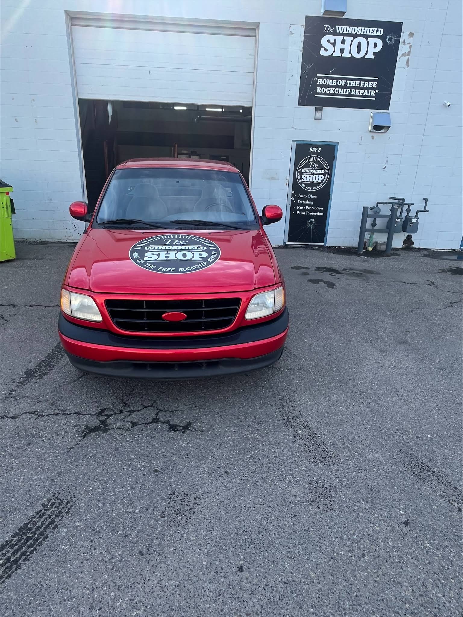 The Windshield Shop branded red truck outside the shop
